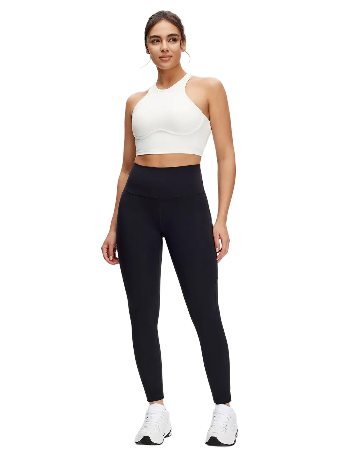 Woman wearing a white sports bra and black leggings on a white background