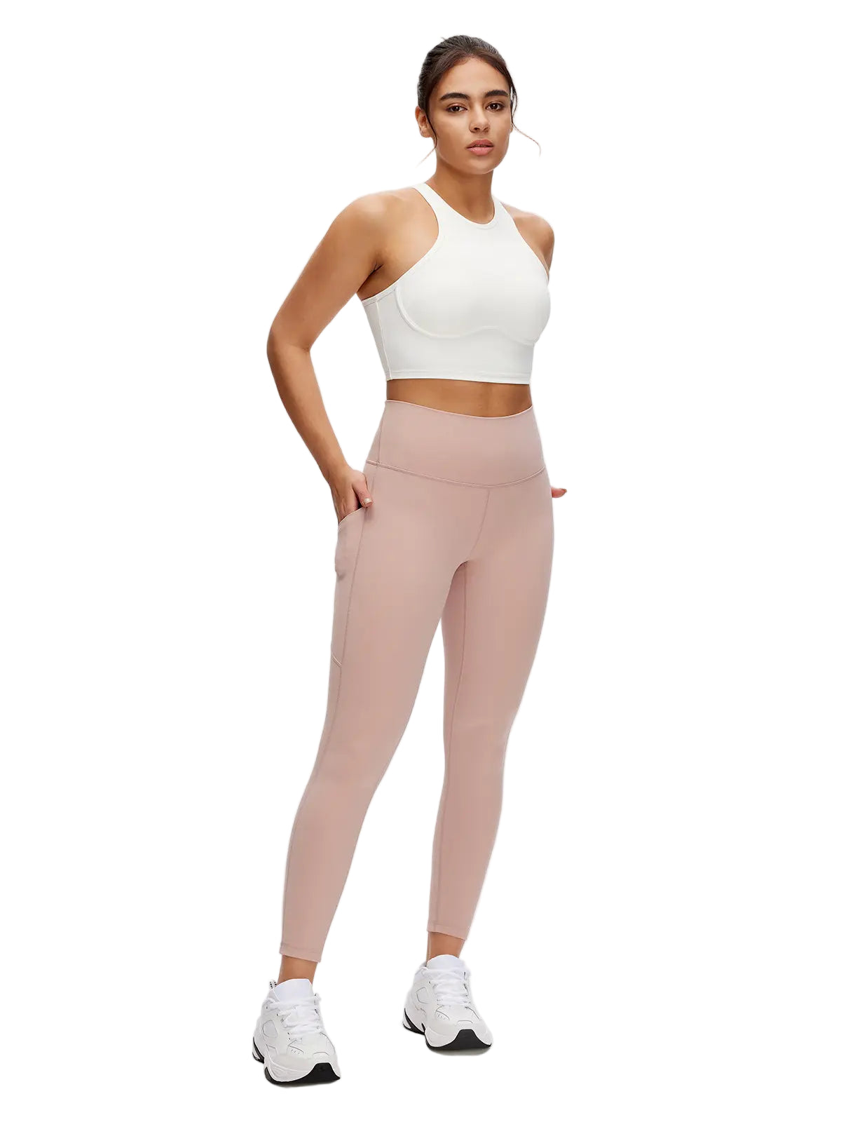 Woman wearing a white crop top and pink leggings on a white background