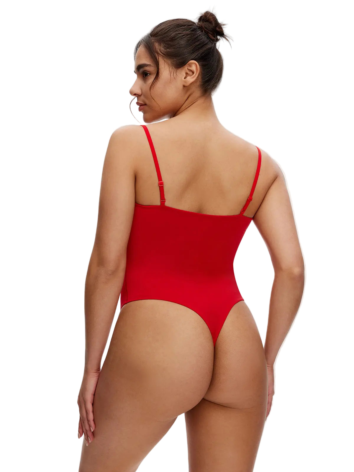 Woman wearing a red swimsuit with cut-out design on a plain background