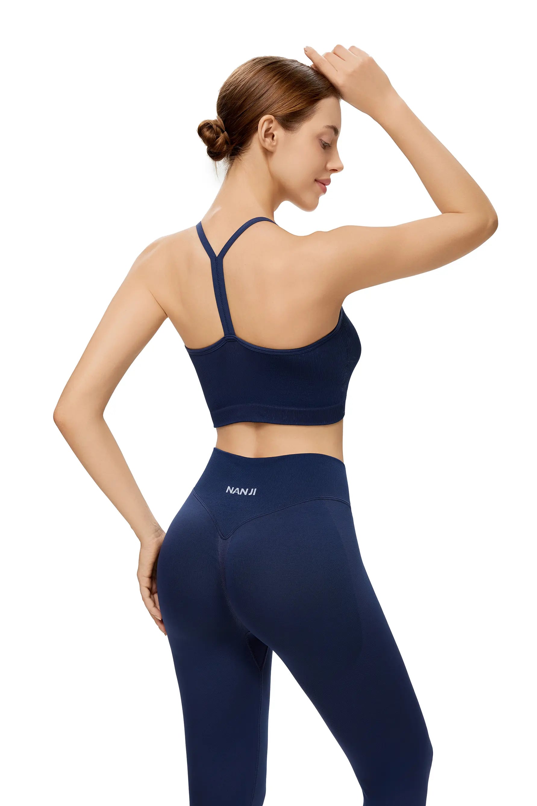 Woman wearing a navy blue sports bra and leggings with 'Nanii' branding on a white background