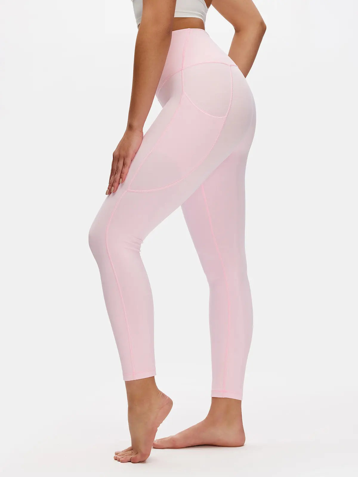Person wearing light pink leggings on a white background