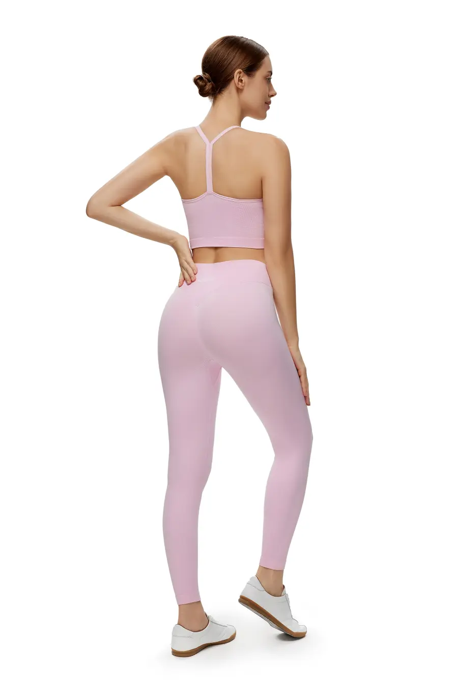 Woman wearing a pink athletic outfit on a white background