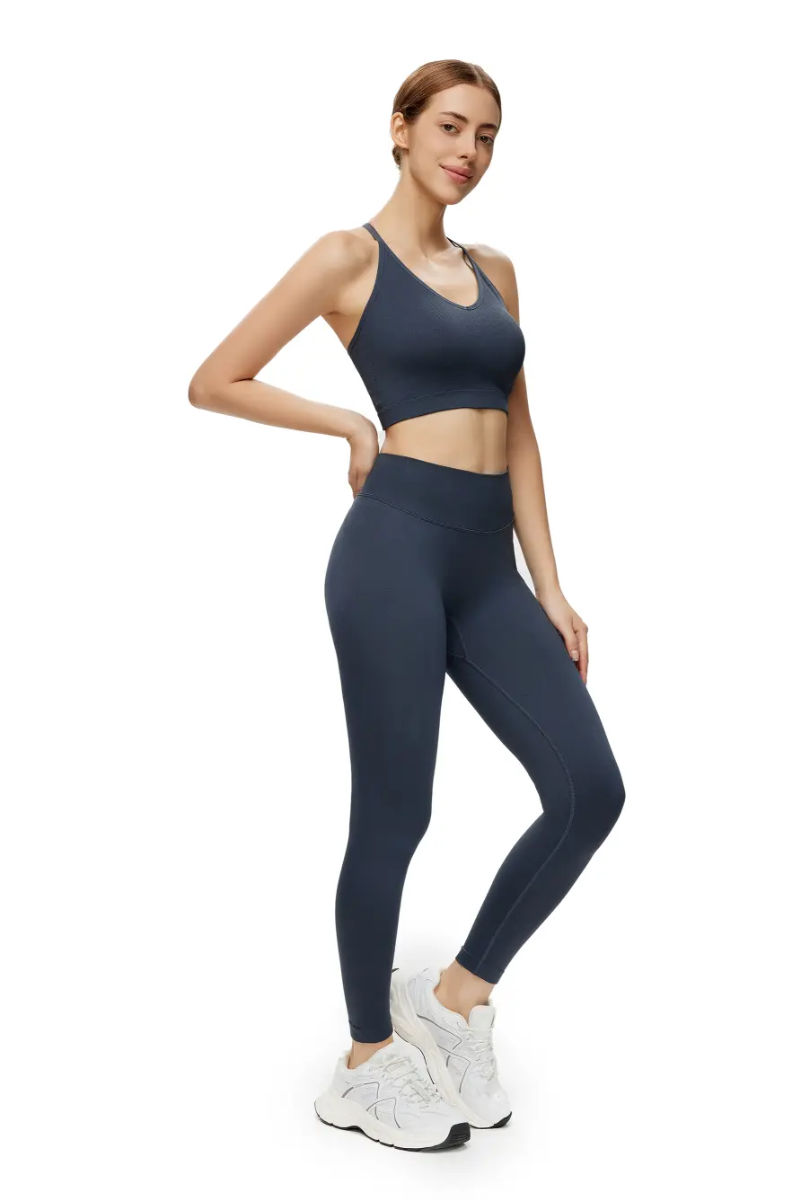 Woman wearing a navy blue athletic outfit on a white background